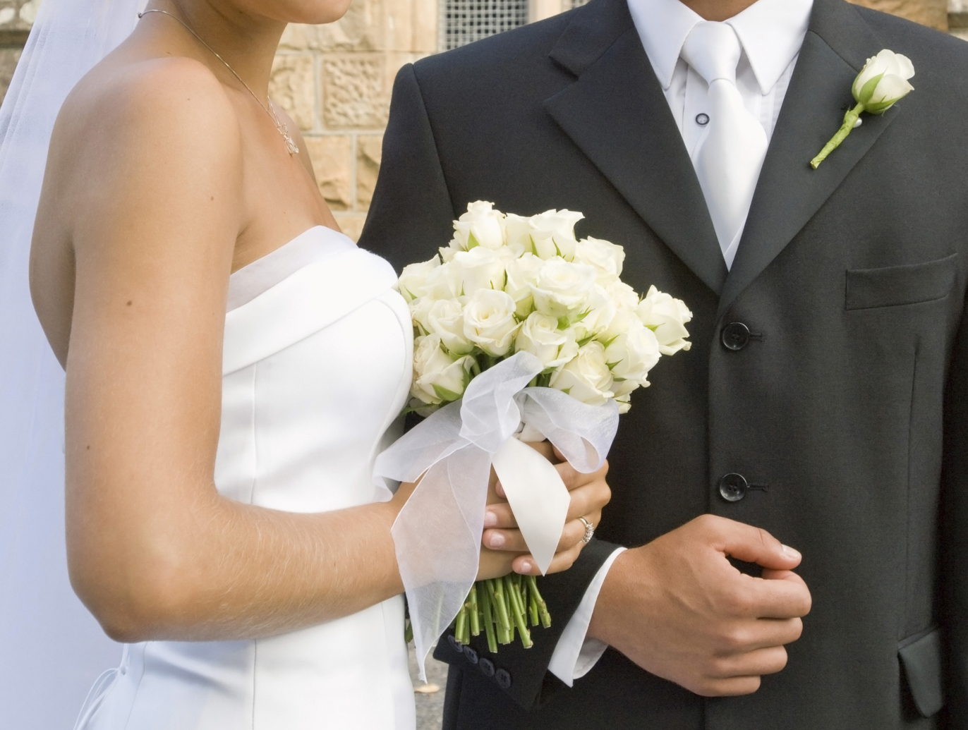 Portrait of bride and groom by church