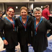 Helen Bolton, Lions Gate Chorus director Sandy Marron and Kali Caramia.