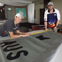 Beldon resident Colin Spence (right) with an assistant measuring a Moth class sail being used in the World Championship Series being held on the Swan River this week.