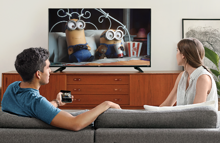 Two people watching a TV powered by Chromecast.