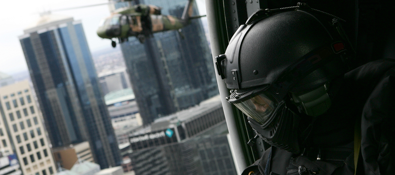 Special forces soldier in helicopter flying over cityscape