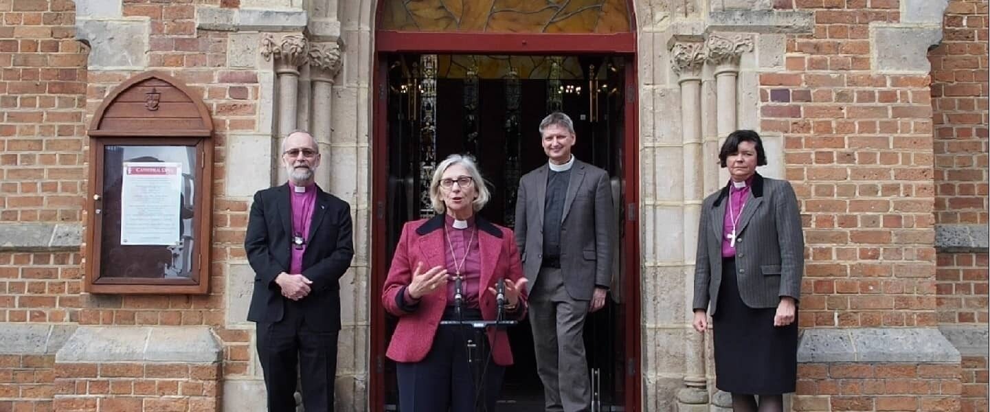 Archbishop Jeremy Kate and Chris at St Georges Cathedral banner
