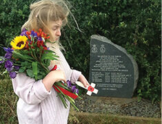6 Remembrance Day IMAGE 2 Imogen James about to place the cross of remembrance and flowers on the memorial