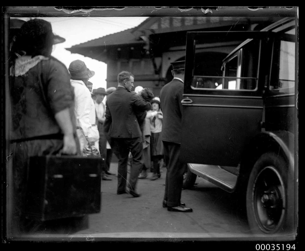 Photograph of man carrying an injured boy