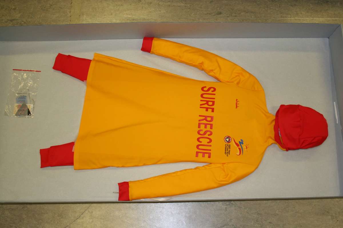 Swimwear is stored on archival cardboard shelving within archival boxes.