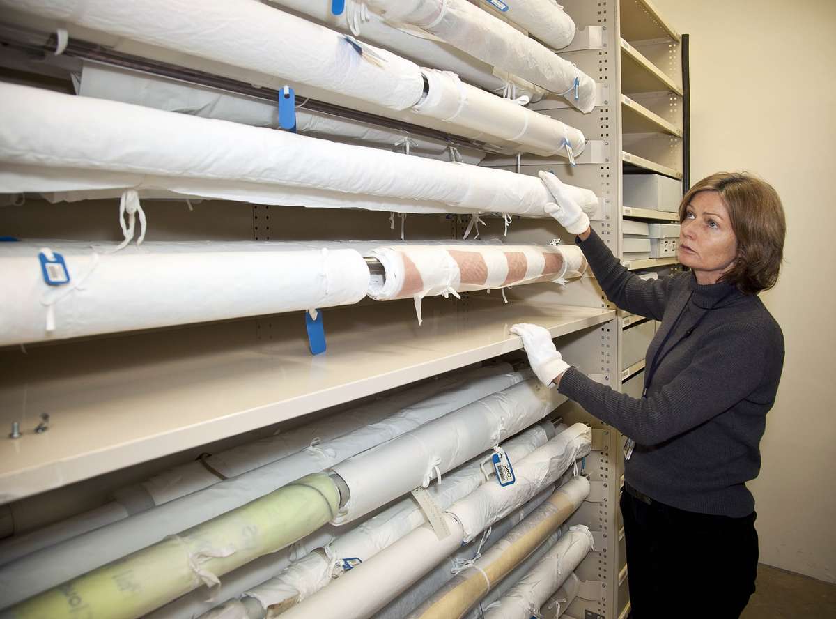 The conservator shows rolled storage method.