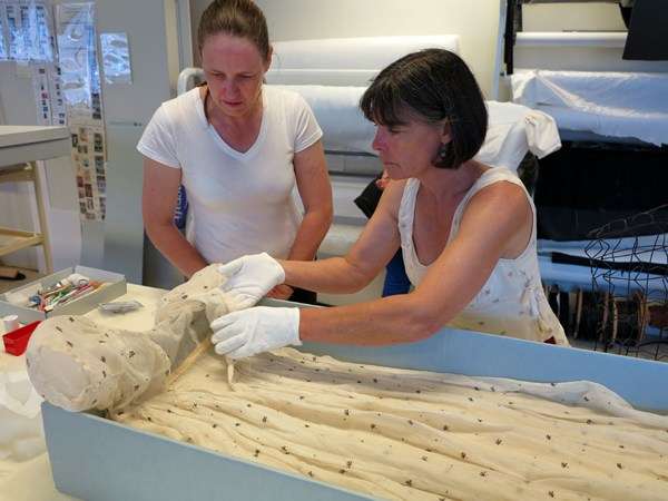 Two women inspecting muslin dress