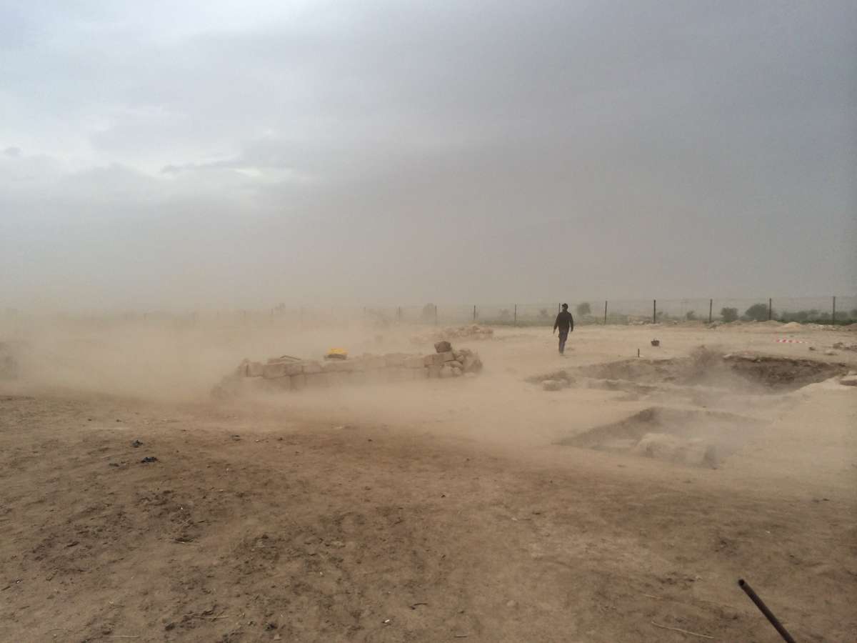 Archaeologist Dr Andrew Madden walking through a duststorm at the site of Khirbat ash-Shaykh ‘Īsā. Photo: Peter Edwell 2013