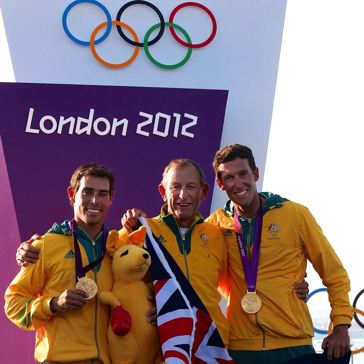 Skipper Mathew Belcher, coach Victor Kovalenko, crew Malcolm Page on the gold medal podium, London 2012 Olympic Games