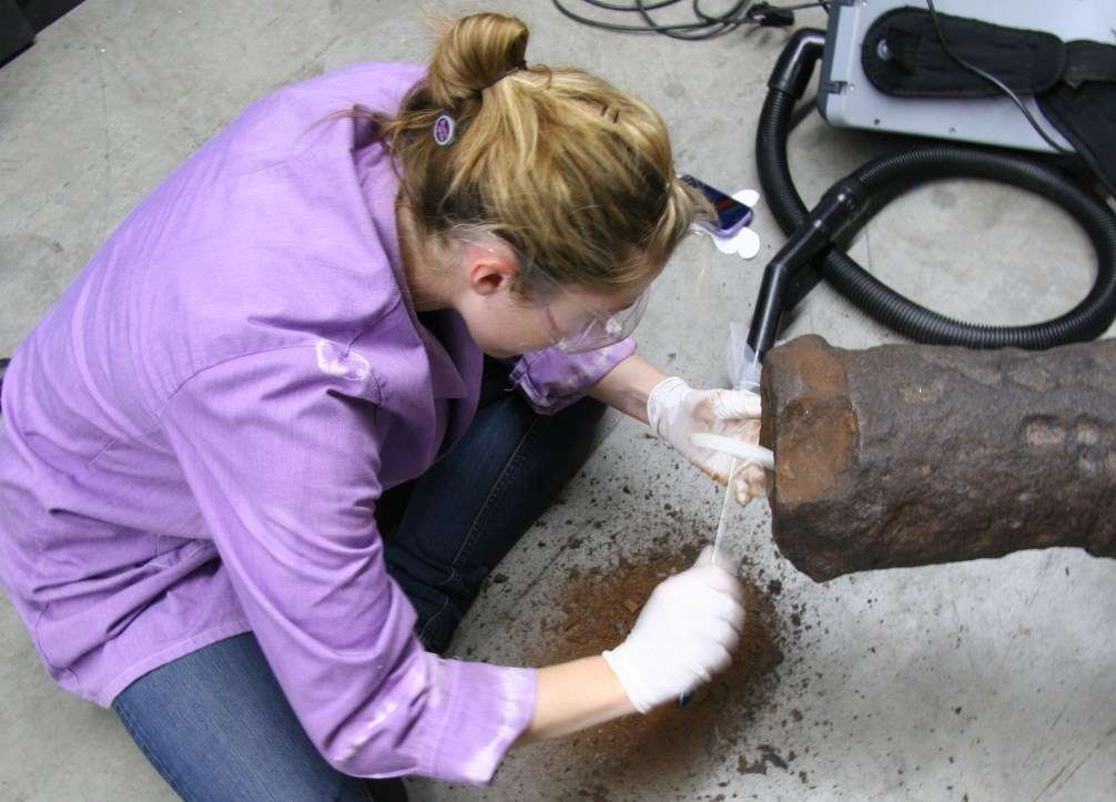 Removing corrosion from the mouth of the cannon.