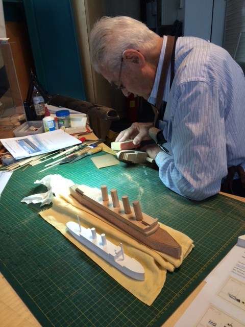 Museum volunteer model maker Col Gibson preparing waterline models for a dazzle paint scheme