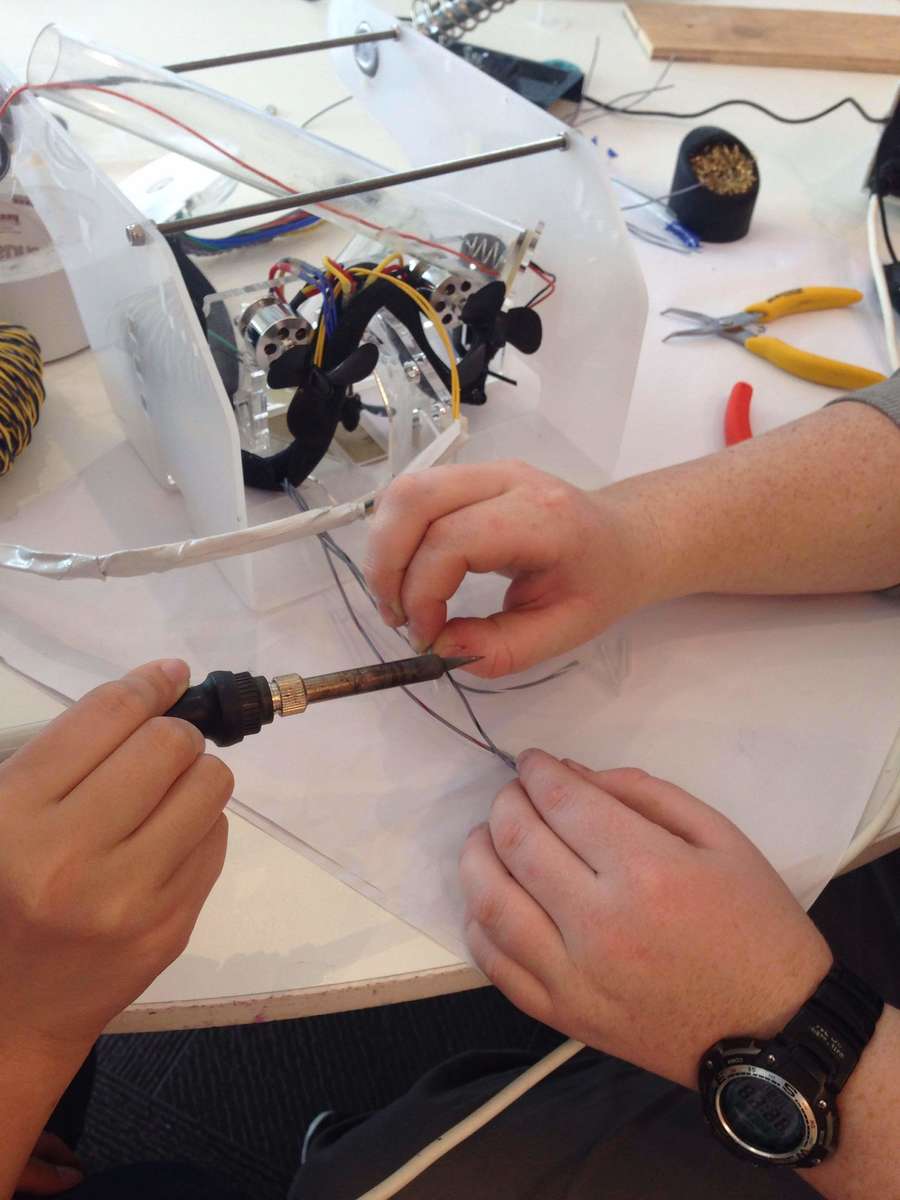 Participants soldering plastic ends onto the ROV