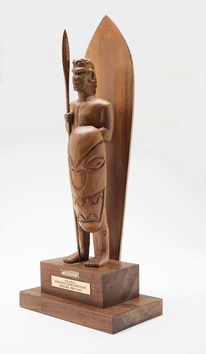 Makaha trophy, 1962, maker unknown, timber, seed and carved timber offerings. Regarded as the unofficial world title, it was won by Bernard ‘Midget’ Farrelly on 2 January 1963. Gift from Bev Farrelly and family in memory of Bernard ‘Midget’ Farrelly. ANMM Collection 00054957.