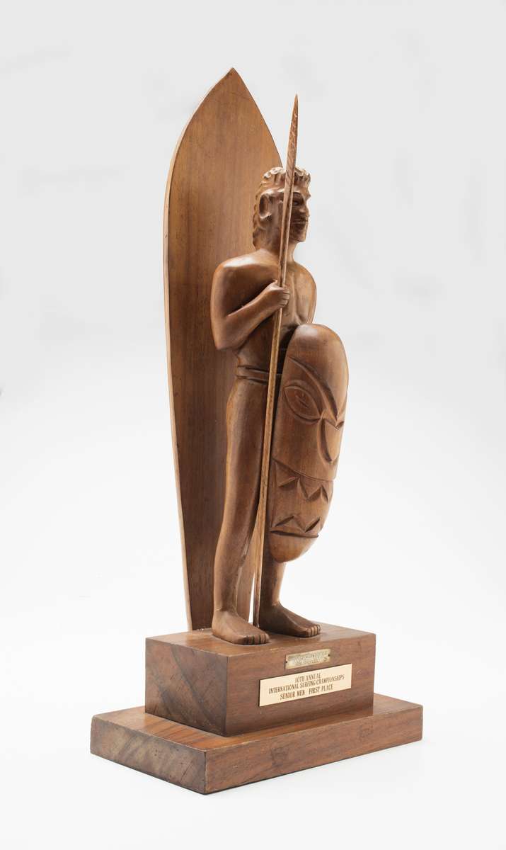 Makaha trophy, 1962, maker unknown, timber, seed and carved timber offerings. Regarded as the unofficial world title, it was won by Bernard ‘Midget’ Farrelly on 2 January 1963. Gift from Bev Farrelly and family in memory of Bernard ‘Midget’ Farrelly. ANMM Collection 00054957.