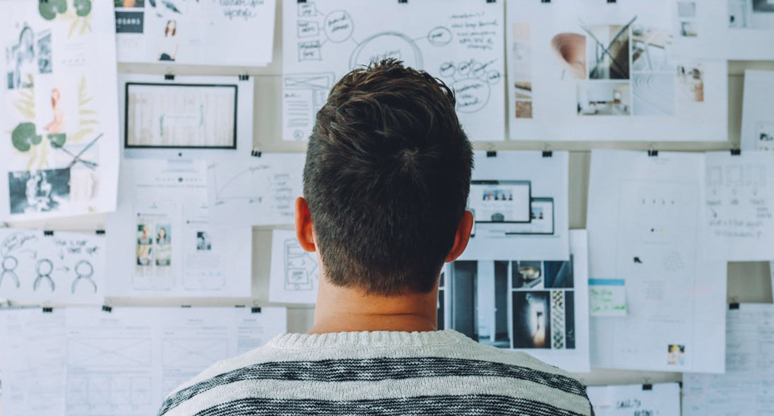 Man looks at pinup wall of creative ideas | The role of the creative director hasn't changed says Frank Morabito