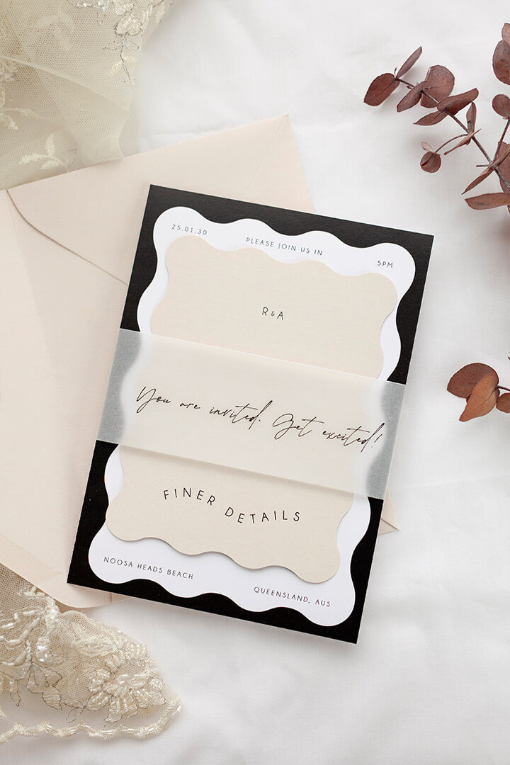 Soft Neue wedding invitation suite with vellum band, scalloped arch design, cream stock, and eucalyptus styling