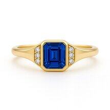 Blue sapphire octagon step cut engagement ring in 18K yellow gold with side diamonds by Brilliyond Jewellery, front view.