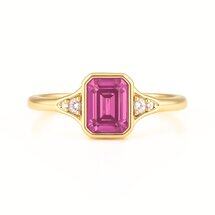 Octagon step cut pink sapphire ring with side diamonds in 18K yellow gold by Brilliyond Jewellery, angled view.