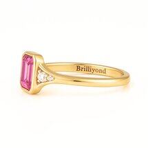 Brilliyond Jewellery’s octagon step cut pink sapphire ring with side diamonds in 18K yellow gold, The Rosella.