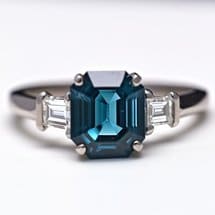 Teal sapphire three stone engagement ring with diamond side stones