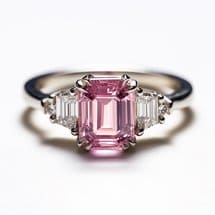 Pink sapphire three stone engagement ring with slim metal band