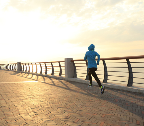 young fitness woman runner running at sunrise seaside