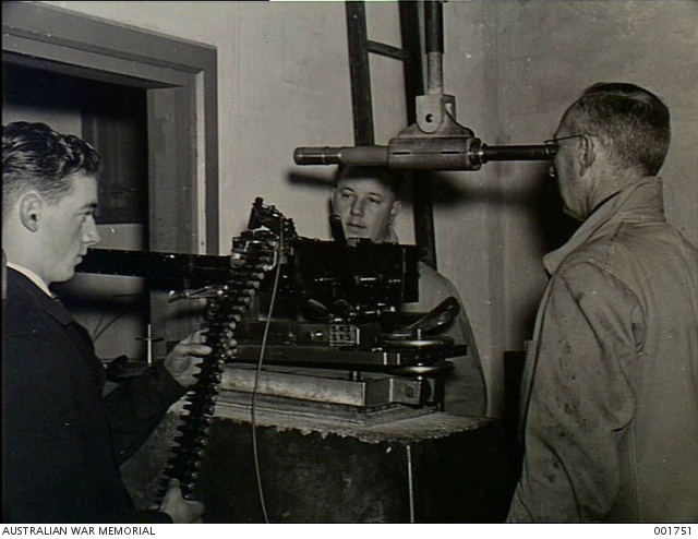 Munitions employees at the Small Arms Factory testing fighter machine ...