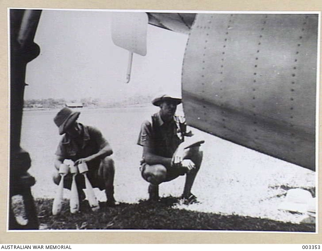 A SERGEANT OF THE RAAF WITH ONE OF THE AIRCRAFTMEN FITTING PRACTICE ...