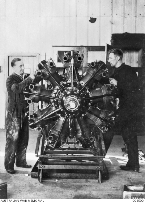 Probably ENGLAND. TWO RAAF AIRCRAFT FITTERS AT WORK ON AN ENGINE. THEY ...