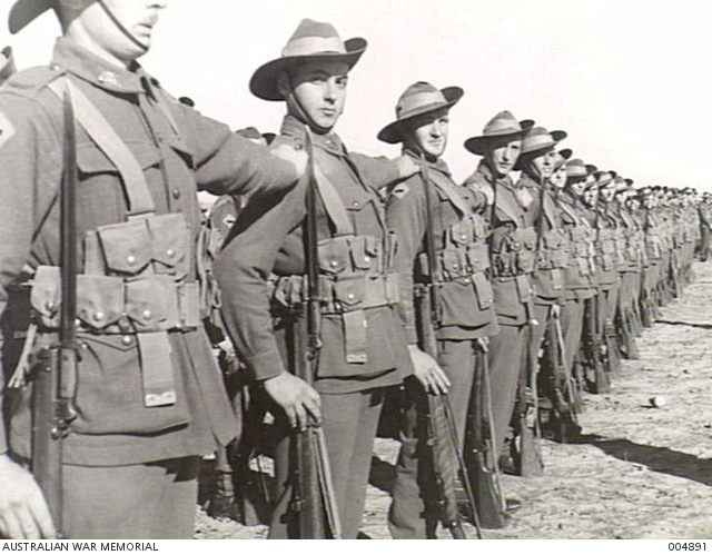 Troops of a unit of the 7th Division respond to the order 'Right Dress' as  they form up on parade ... | Australian War Memorial