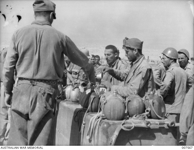 TOBRUK. ITALIAN PRISONERS AT TOBRUK FILLING THEIR WATER BOTTLES AT THE ...