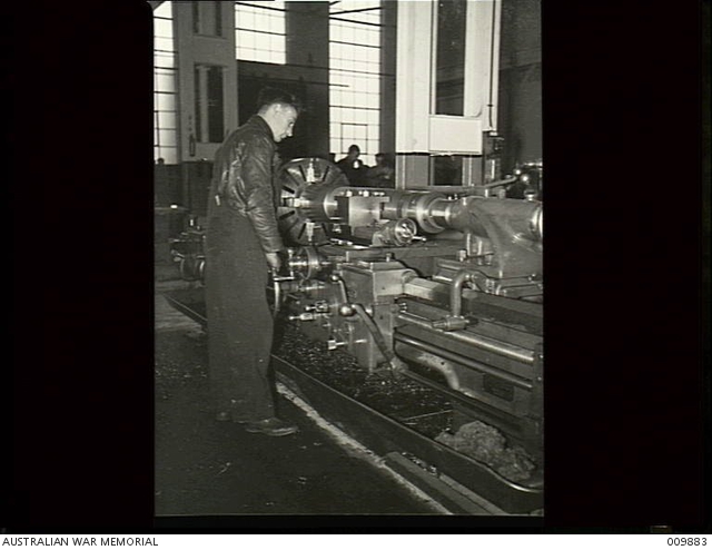 A machine operator turning a jacket into which the barrel of a British ...