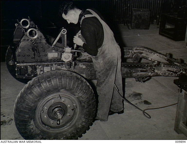 A workman preparing the gun saddle of a 25 pounder British designed ...