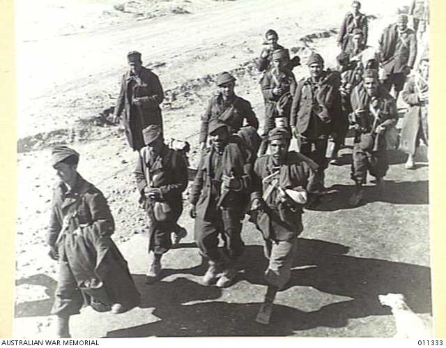 WESTERN DESERT. ITALIAN PRISONERS ARE MARCHED OFF TO THE CAGE ...