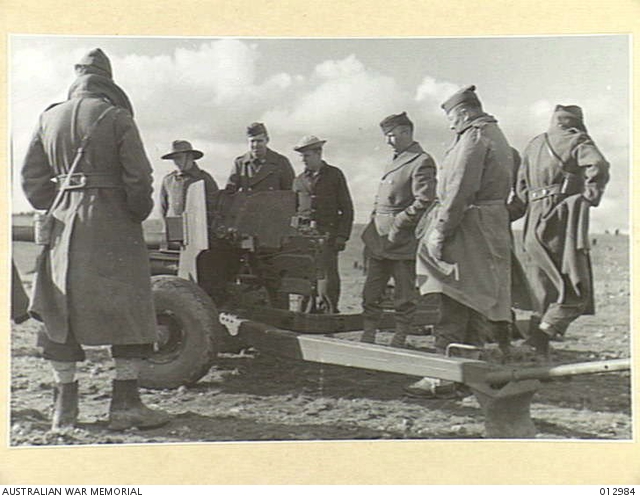 U.S. AND AUSTRALIAN PERSONNEL EXAMINING THE GUN ON THE FIRING RANGE ...