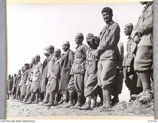 ITALIAN PRISONERS IN THE WESTERN DESERT. THESE PRISONERS ARE LINED UP ...