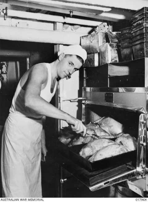 Checking the turkeys cooking in the oven for Christmas dinner on HMAS ...