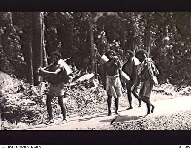 REINHOLD HIGHWAY, NEW GUINEA, 1943-08-31. NATIVE ROAD WORKERS COMING ...