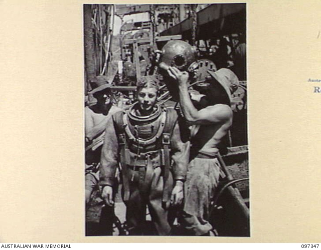 RABAUL, NEW BRITAIN. 1945-09-30. DIVER J. DALLEY BEING RELIEVED OF HIS ...