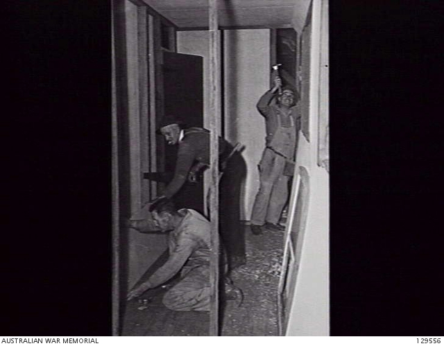 HERNE BAY, NSW. 1946-06-11. CARPENTERS WORKING ON A FIBRO PARTITION IN ...