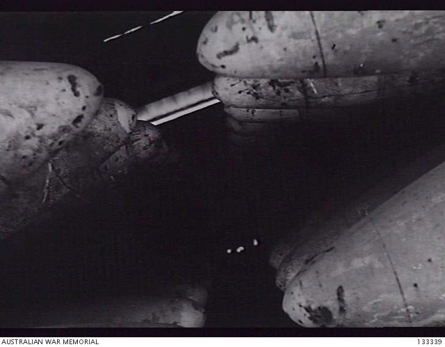 KIRIGUSHI, JAPAN. 1946. RACKS OF HEAVY CALIBRE SHELLS IN A STOREHOUSE ...