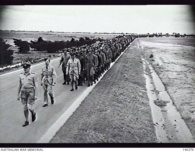 POINT COOK, VIC. 1944-01-11. MEMBERS OF THE RAAF MARCHING TO WORK ALONG ...