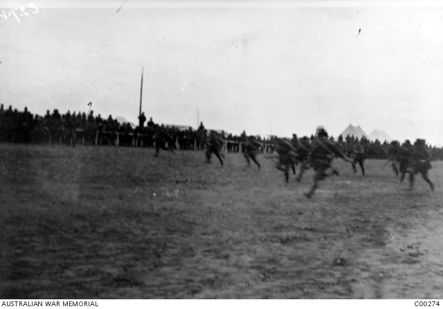 Spectators at a sports meeting watch an event known as the marching ...