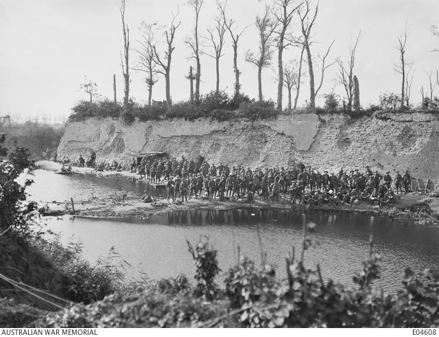 A large group of unidentified Australian troops resting along the town ...