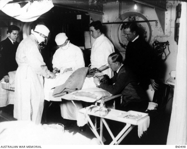 Medical officers perform an operation in the sick bay aboard HMAS ...