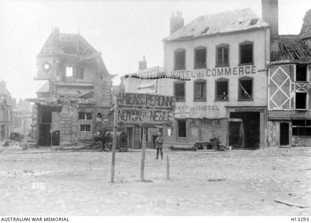 Roye, France. May 1918. War damaged buildings around the market place ...