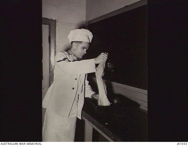 IWAKUNI, JAPAN. 1953. A CORPORAL COOK PREPARES ONE OF THE RABBITS BRED ...