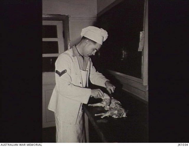 IWAKUNI, JAPAN. 1953. A CORPORAL COOK PREPARES ONE OF THE RABBITS BRED ...