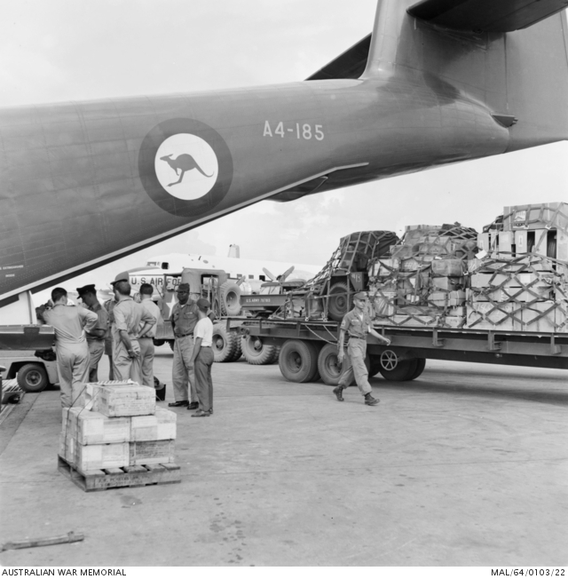 RAAF loadmasters discuss the next cargo load by the tail of an RAAF ...