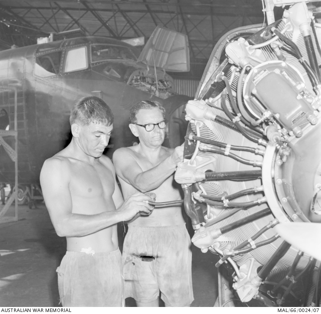 Inside a hangar at Vung Tau, two RAAF engine fitters work on the engine ...